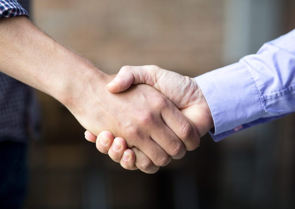 Manos estrechándose en señal de acuerdo para comparar cuotas de casas de apuestas en Peru.